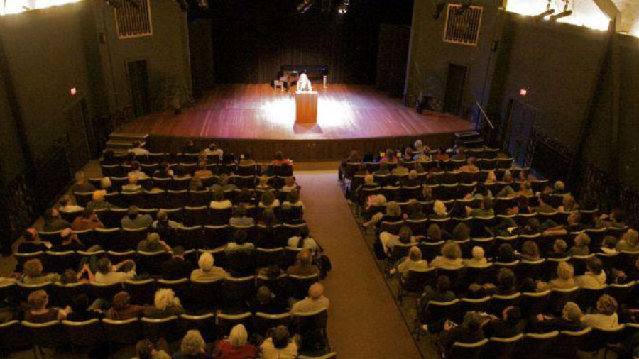 writer on stage reading to audience